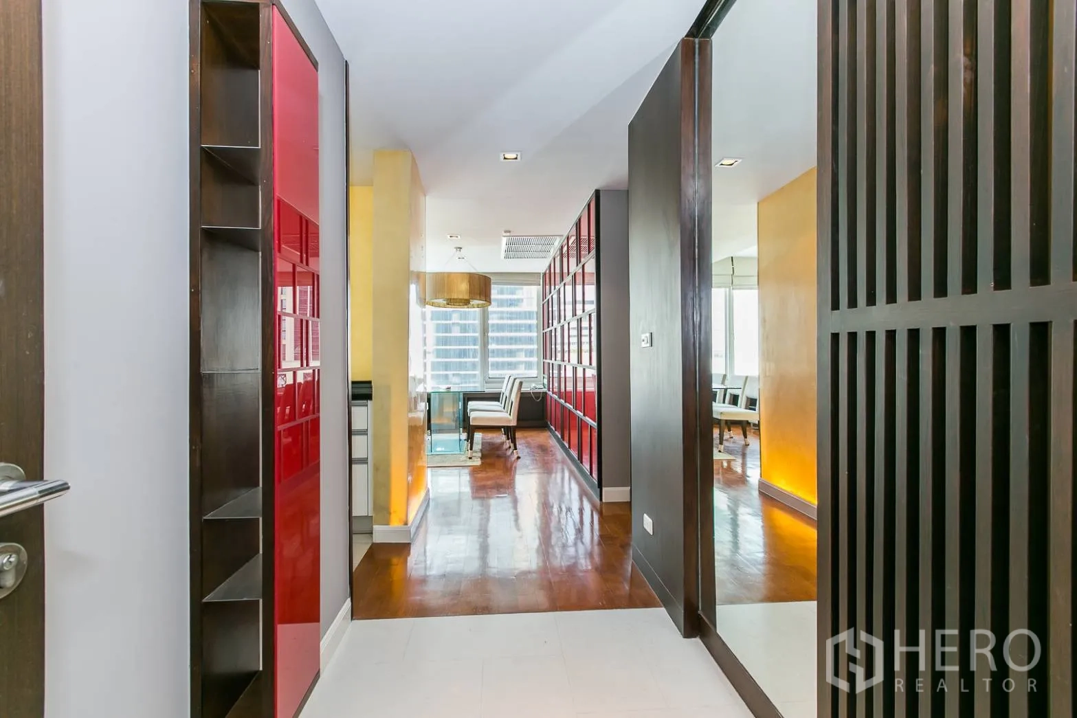 公寓 出租或出售在Khlong Toei, Bangkok - 入户走廊带红色展示柜与大镜面，通向客厅。