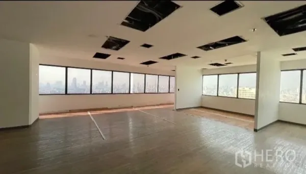 Office Space for rent or sale - Large open-plan workspace with panoramic windows and wood-style flooring.