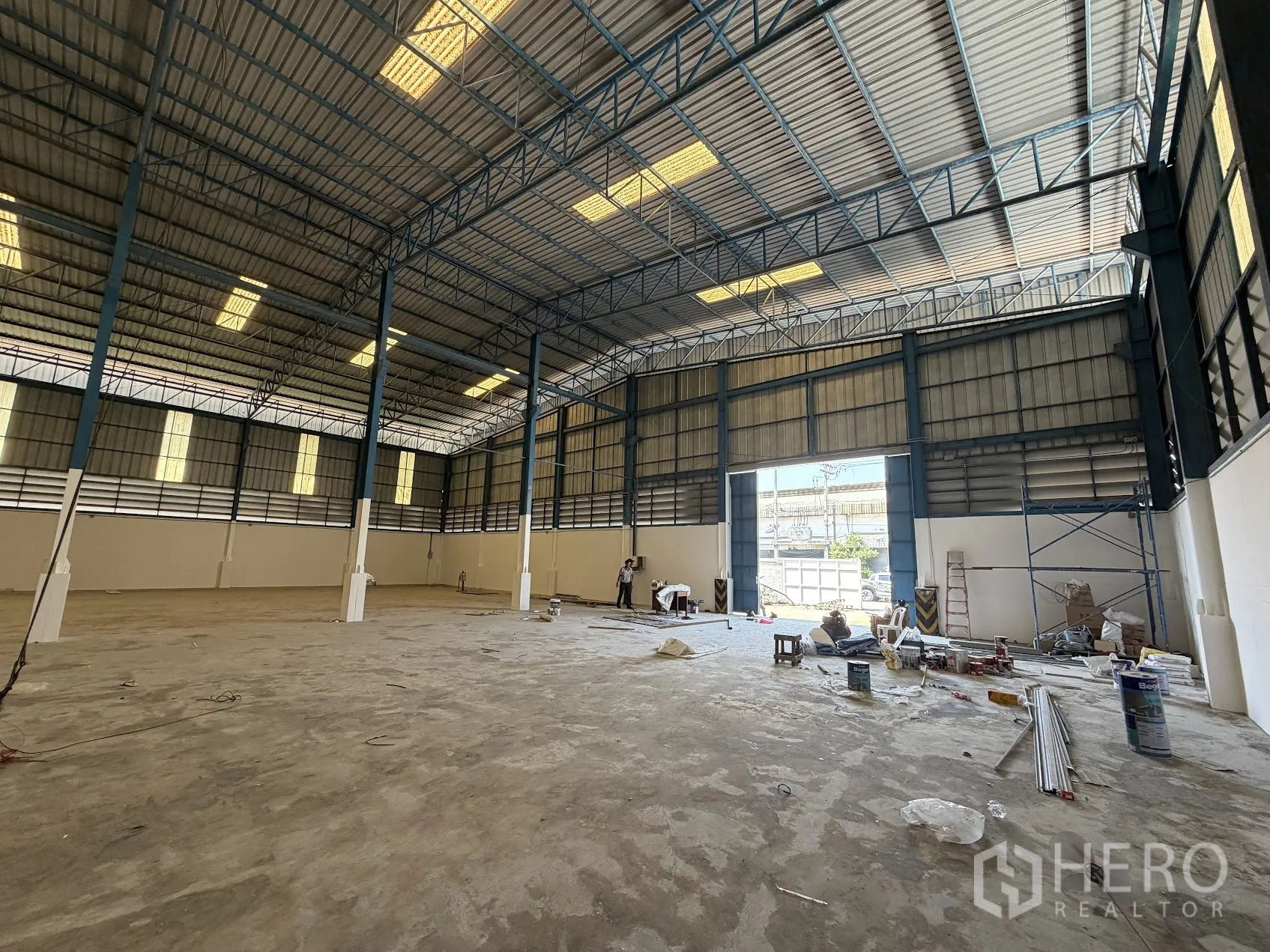 โรงงาน for rent in Bang Sao Thong, Samut Prakan - โซนขนถ่ายสินค้าพร้อมประตูม้วนกว้าง พื้นคอนกรีต และอุปกรณ์ระหว่างปรับปรุง