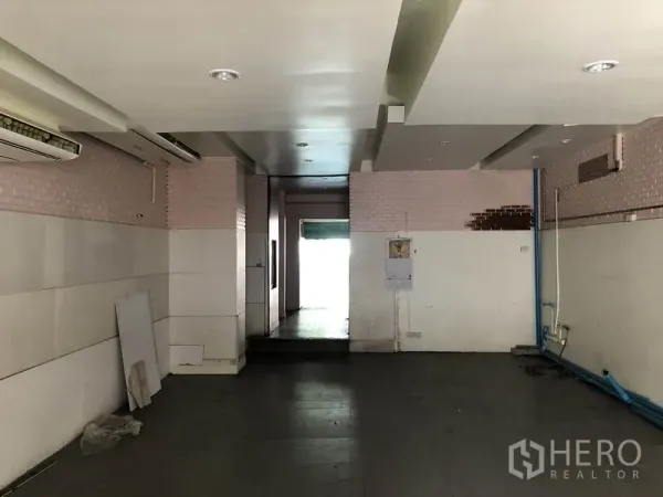 带办公室的家 出租或出售在Huai Khwang, Bangkok - 后勤区域，低天花与墙面饰板，可见蓝色管线与后门。