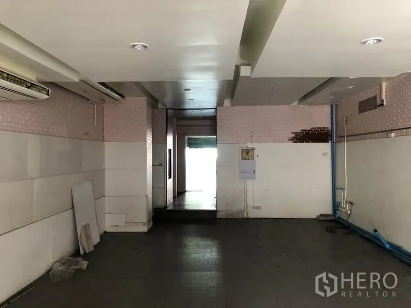 带办公室的家 出租或出售在Huai Khwang, Bangkok - 后勤区域，低天花与墙面饰板，可见蓝色管线与后门。