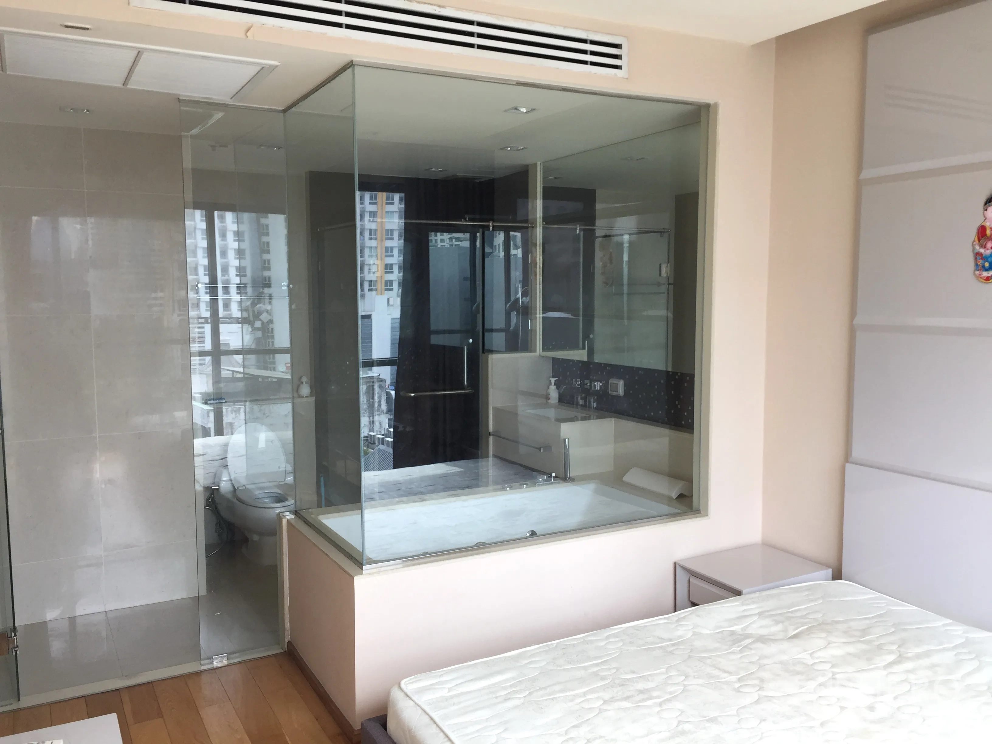 Condominium for rent in Bang Rak, Bangkok - Glass-walled en-suite bathroom off the master bedroom featuring a bathtub and separate shower.