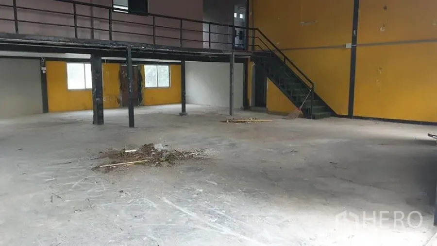 货栈 出租在Huai Khwang, Bangkok - 仓库内部宽敞，混凝土地面，钢结构夹层与楼梯，黄色墙面