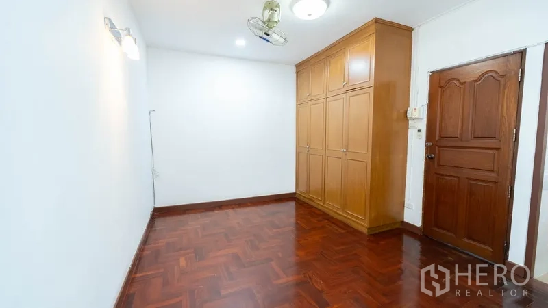 联排别墅 出租在Khlong Toei, Bangkok - 卧室配内置木衣柜与实木门。