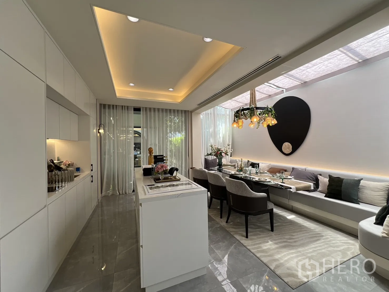 Semi-detached House for sale in Yan Nawa, Bangkok - Another view of the kitchen and long banquette dining corner under a pendant chandelier.
