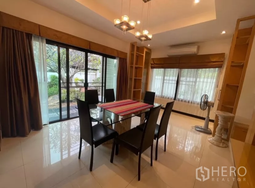 Detached House for rent in Chatuchak, Bangkok - Dining room with pendant lights and sliding glass doors opening to the garden.