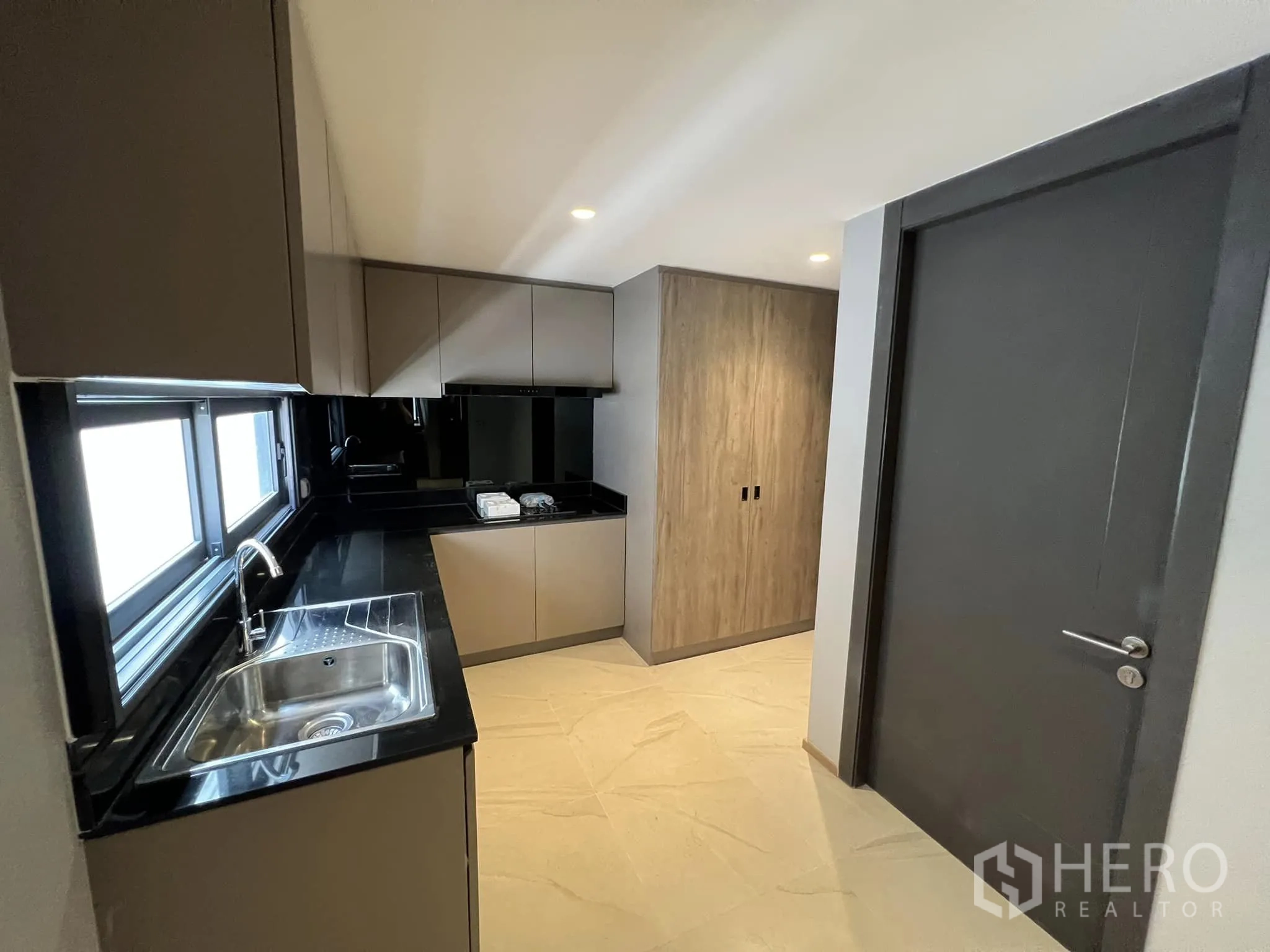 Detached House for rent or sale in Yan Nawa, Bangkok - Separate Thai kitchen with black countertops and window.