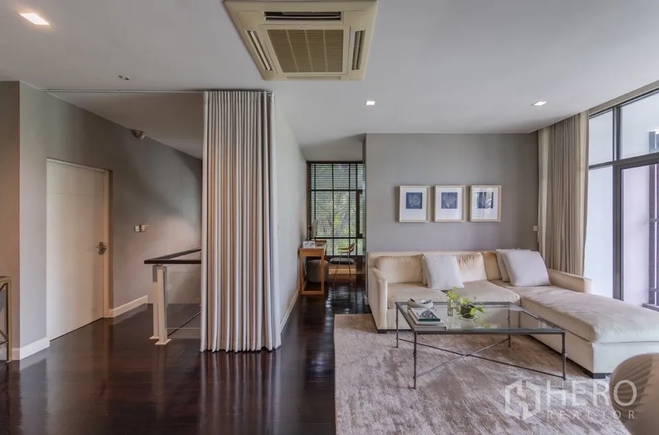 独栋房屋 for rent or sale in Bang Kapi, Bangkok - 起居区，L型沙发、玻璃茶几和大窗。