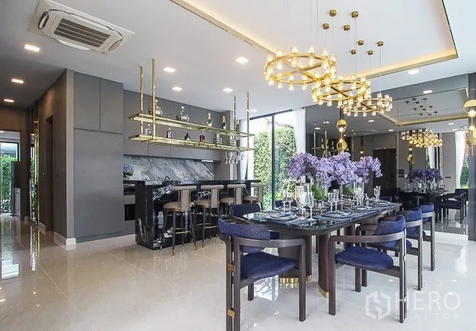 独立式住宅 出租或出售在Prawet, Bangkok - 餐区带吧台与金色吊灯，观景落地窗