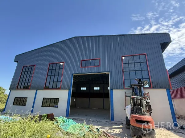 Warehouse for rent in Lam Luk Ka, Pathum Thani - Newly built warehouse facade with tall glass windows and wide 5x5 m electric shutter door.