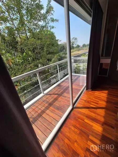Detached House for rent in Bang Kruai, Nonthaburi - Slim balcony with wooden decking and white railing overlooking trees.
