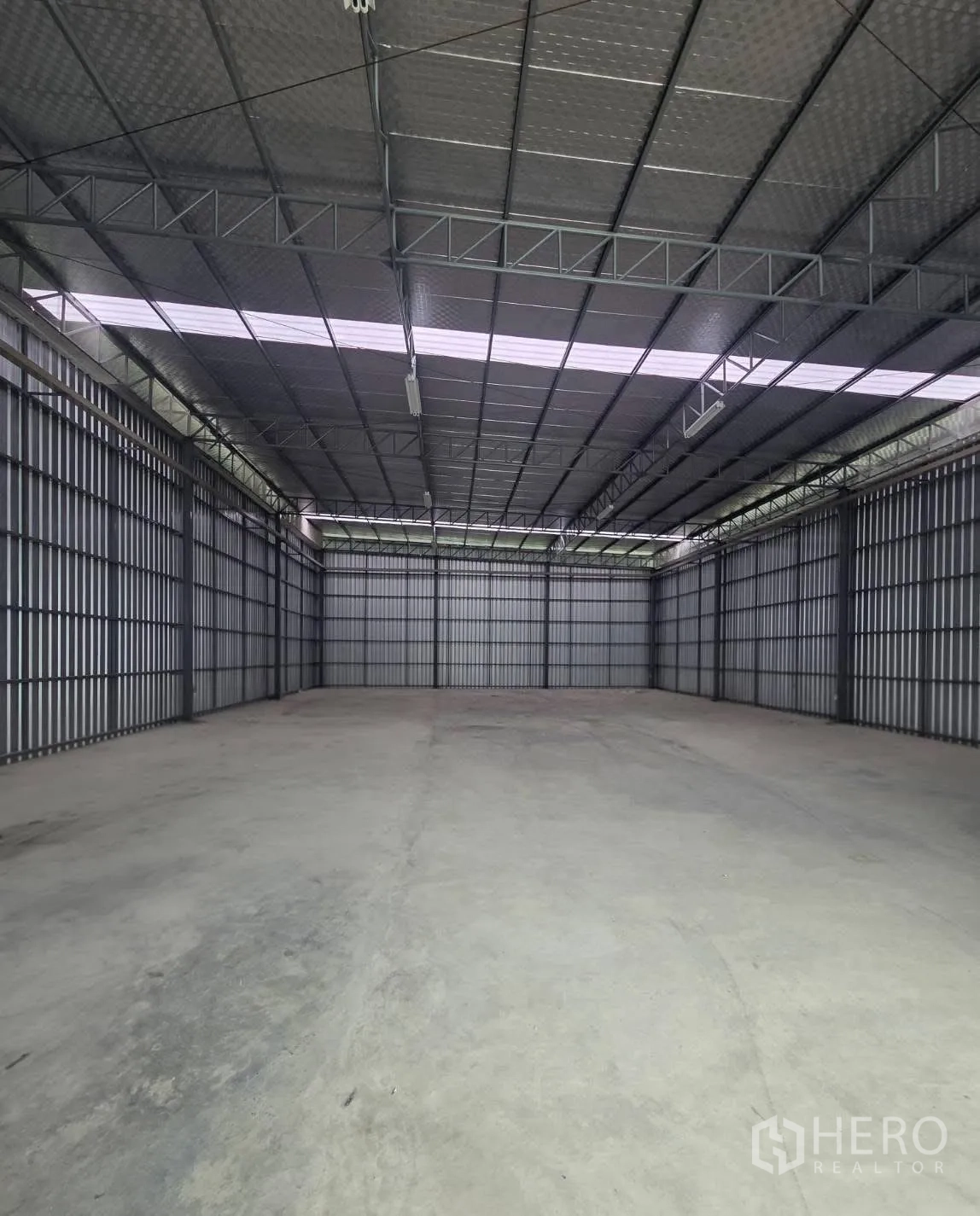 Factory for rent in Mueang Samut Prakan, Samut Prakan - Expansive warehouse floor with steel frame walls and fluorescent lighting.