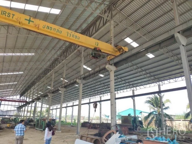 โรงงาน ให้เช่าในSamut Sakhon - รายละเอียดเครนเหนือศีรษะสีเหลืองภายในโกดัง มีต้นปาล์มนอกอาคาร สมุทรสาคร