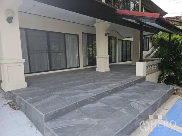 บ้าน ให้เช่า - เฉลียงหน้าบ้านกว้าง ปูหินสีเทา พร้อมประตูกระจกบานเลื่อนสูงจรดเพดาน