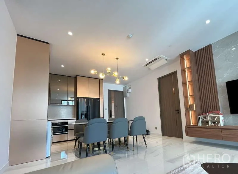 Condominium for rent or sale in Sathon, Bangkok - Spacious dining area for six adjoining the kitchen and lounge under modern lighting.