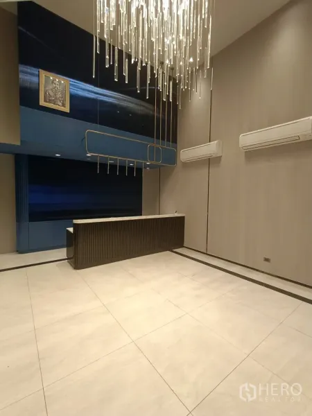 带办公室的家 出租或出售在Phra Khanong, Bangkok - 接待区位于水晶吊灯下，通铺大砖与分体空调，风格雅致。