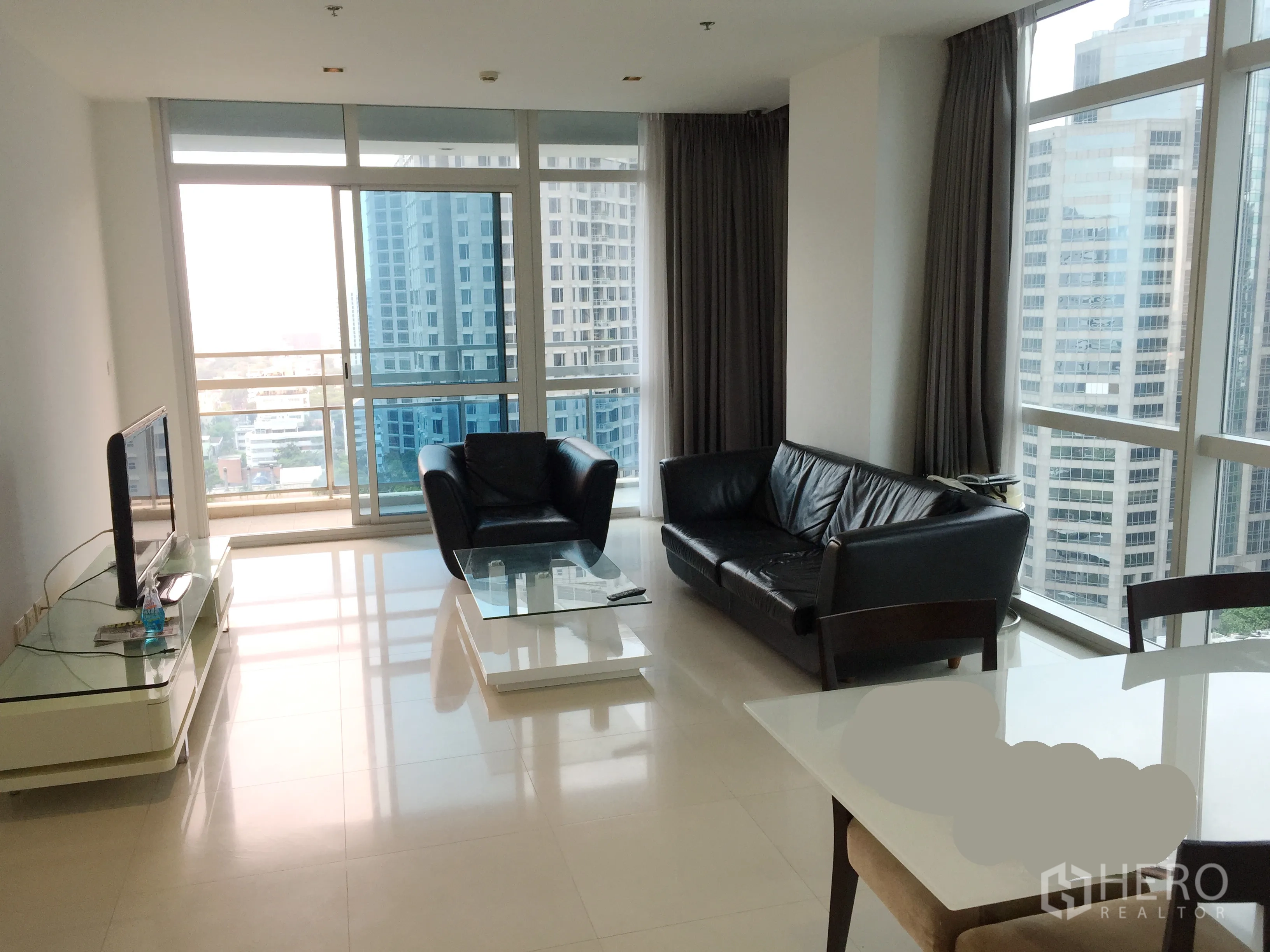 公寓 出租在Pathum Wan, Bangkok - 转角客厅，落地窗与阳台，享曼谷城市景观。