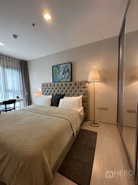 公寓 出租或出售在Khlong Toei, Bangkok - 主卧配绗缝床头板、床头灯与镜面衣柜。