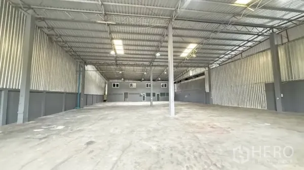Warehouse for rent in Bang Na, Bangkok - Large warehouse interior with high roof, concrete floor and lighting.