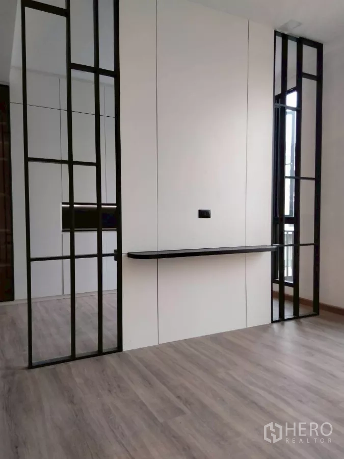 Townhouse for rent in Chatuchak, Bangkok - Feature wall with black frame accents and floating shelf in empty room.
