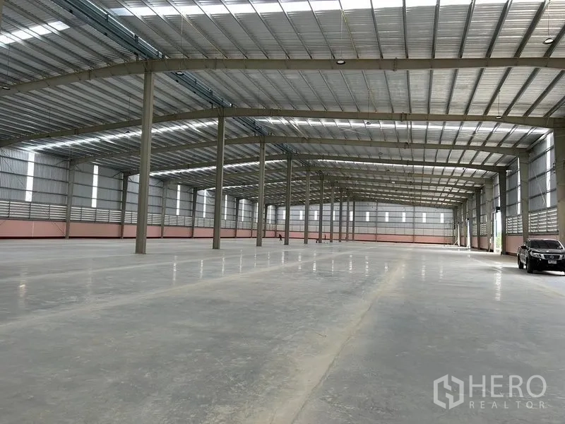 货栈 出租在Nikhom Phatthana, Rayong - 开放式仓储大厅，柱距宽阔，尽端可见车辆出入口。