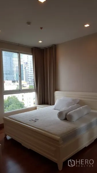 公寓 出租在Bang Rak, Bangkok - 主卧明亮，配大窗与城市景观，设有大床，位于Bang Rak公寓内。