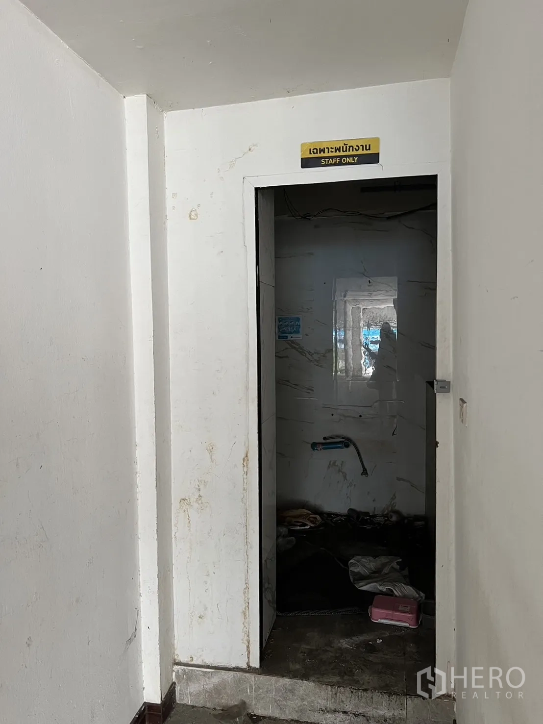 Shophouse for rent in Khlong Toei, Bangkok - Doorway marked staff only opening to a back-of-house utility room with unfinished walls.