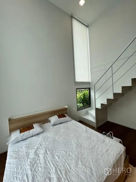 Detached House for rent - View from mezzanine stairs over a high-ceiling bedroom with a tall window.