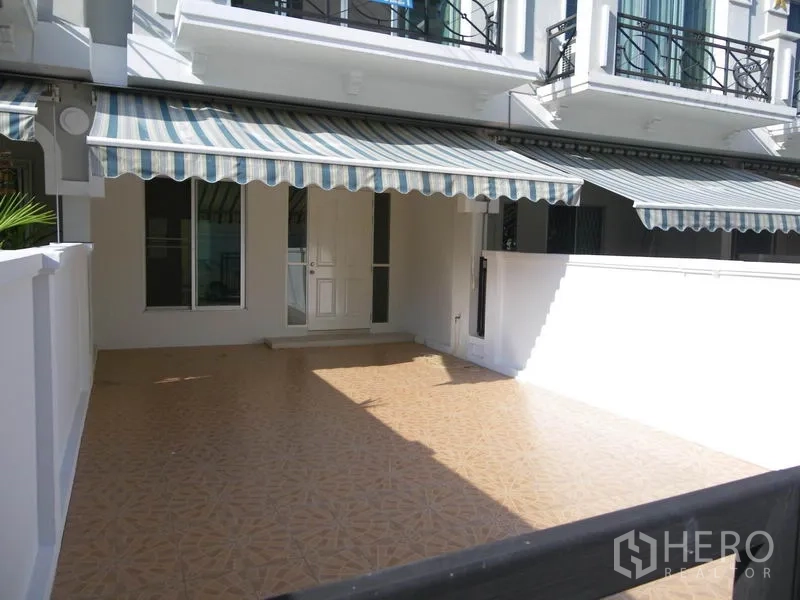 带办公室的家 出租或出售在Suan Luang, Bangkok - 宽阔前露台，条纹遮阳篷与白色围墙，适合停车。