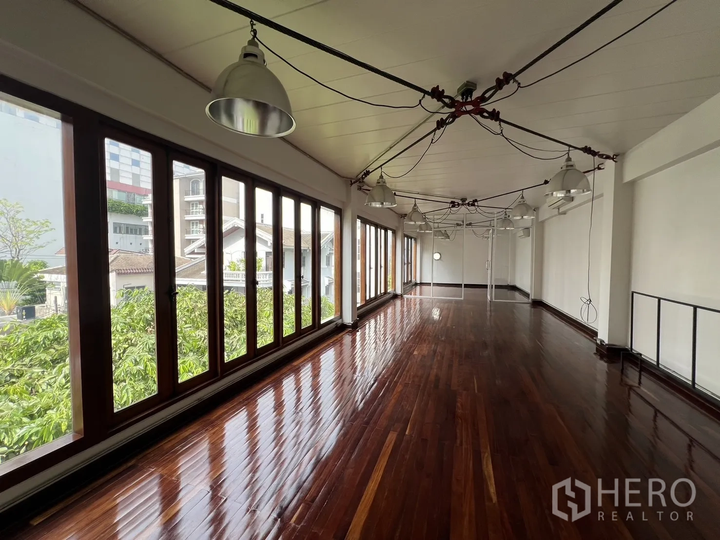 带办公室的家 出租在Watthana, Bangkok - 采光充沛的工作室，连续窗与外露线缆吊灯，深色木地板。