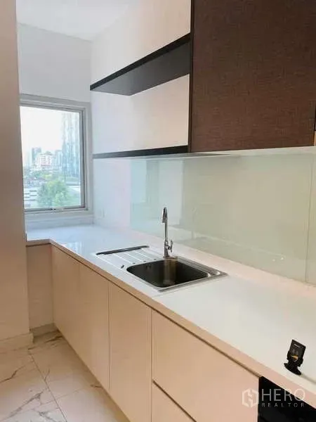 公寓 出租或出售在Watthana, Bangkok - 备用茶水间，长台面与水槽，窗外可见城市景观。