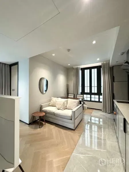 公寓 出租在Watthana, Bangkok - 温馨起居区，沙发与用餐角落，落地窗旁的现代小厨房。