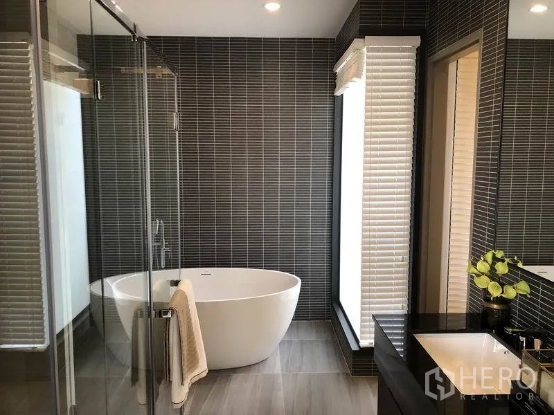 บ้าน ขายในBang Kapi, Bangkok - ห้องน้ำหรูอ่างอาบน้ำลอยตัว ตู้กระจกอาบน้ำ และผนังกระเบื้องสีเข้ม.