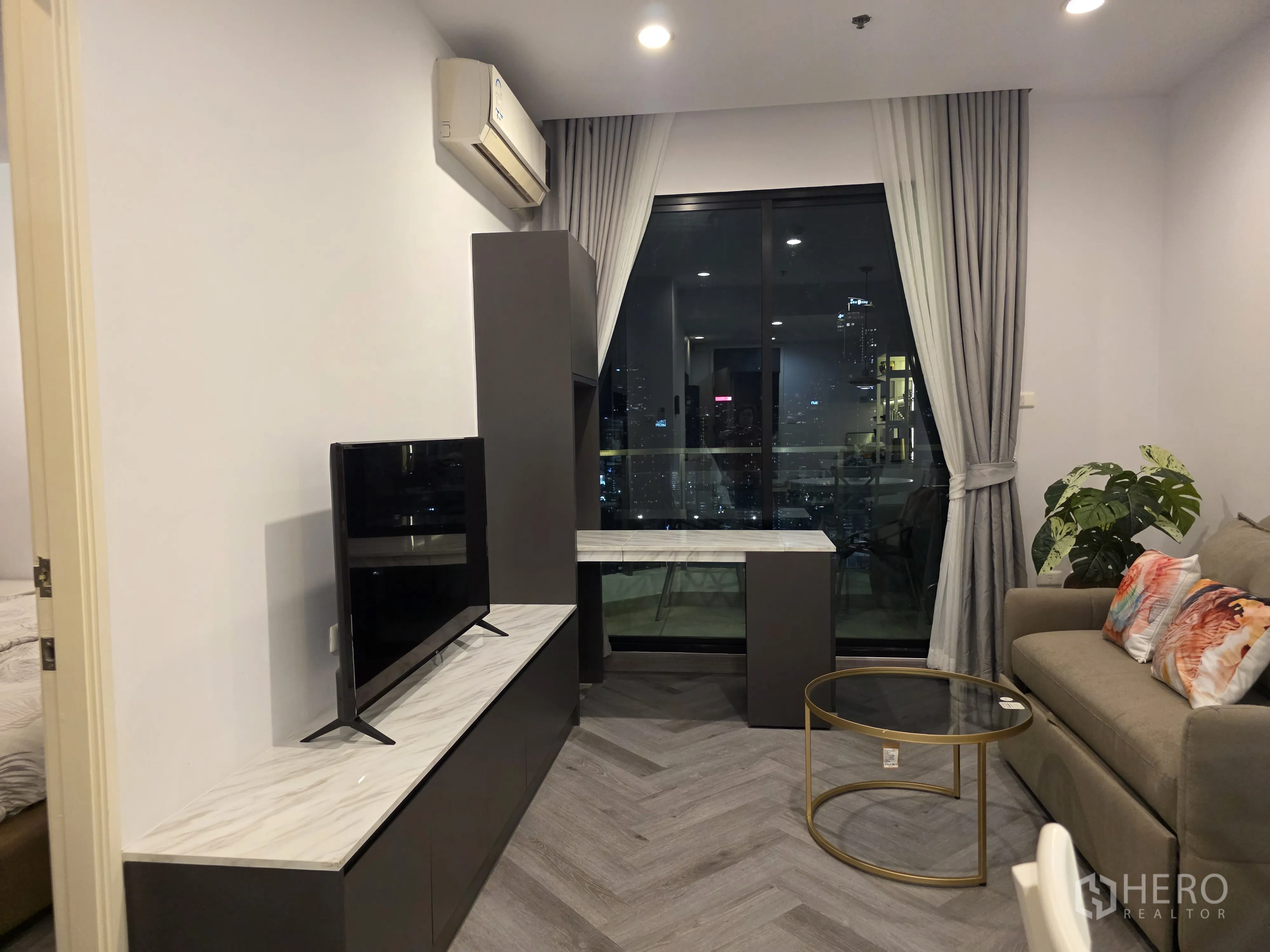 公寓 for rent in Bang Kapi, Bangkok - 客厅设沙发床、电视柜与装饰画，旁有大窗。