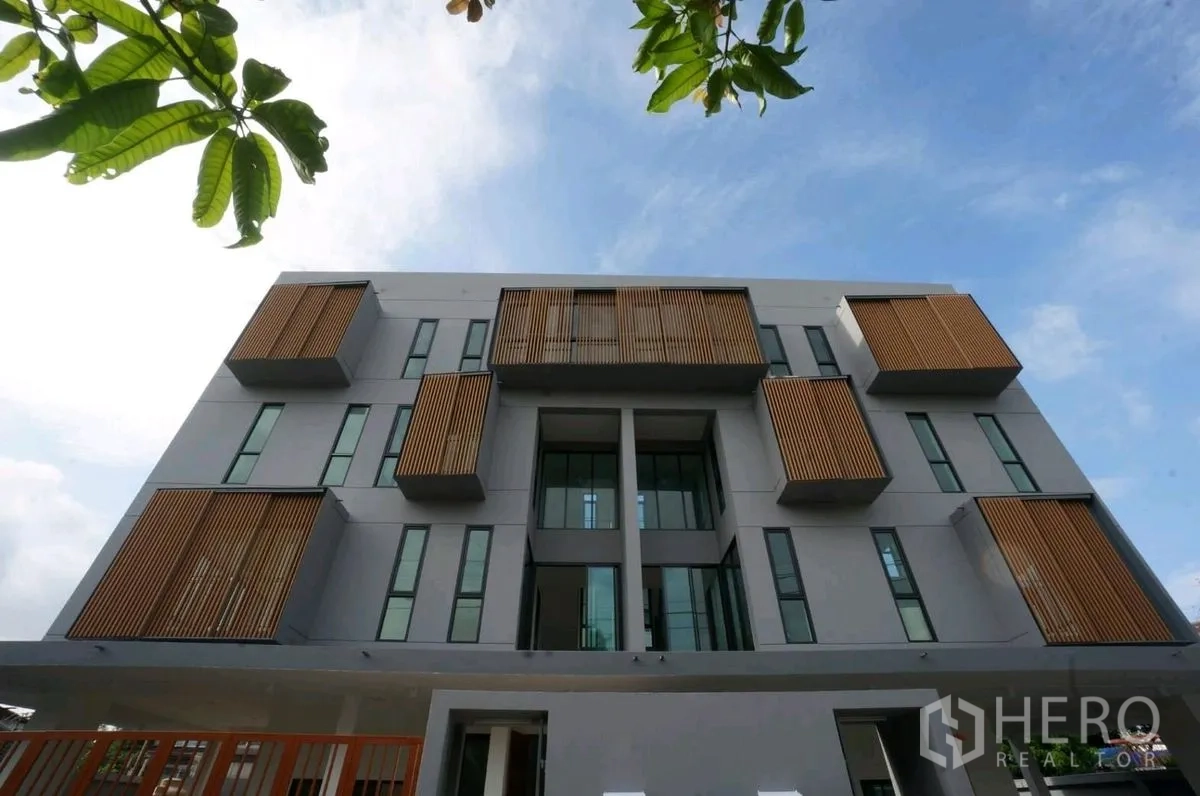 Home Office for rent in Chatuchak, Bangkok - Modern building exterior with vertical wooden screens and large windows.