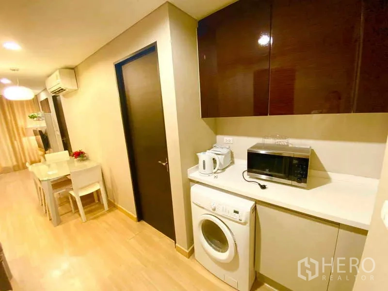 公寓 出租在Ratchathewi, Bangkok - 家务区设台面、壁柜、洗衣机与微波炉，可望餐区。
