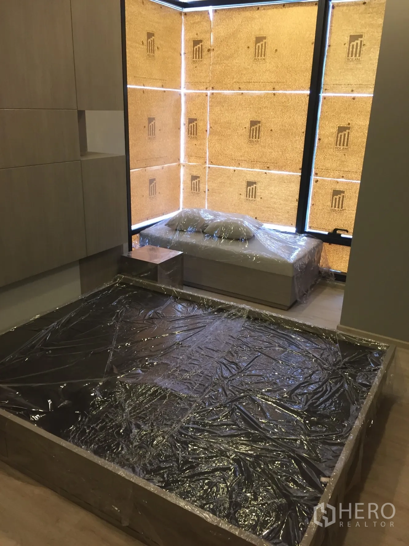 Condominium for rent in Watthana, Bangkok - Bedroom with platform bed frame and floor-to-ceiling corner windows.
