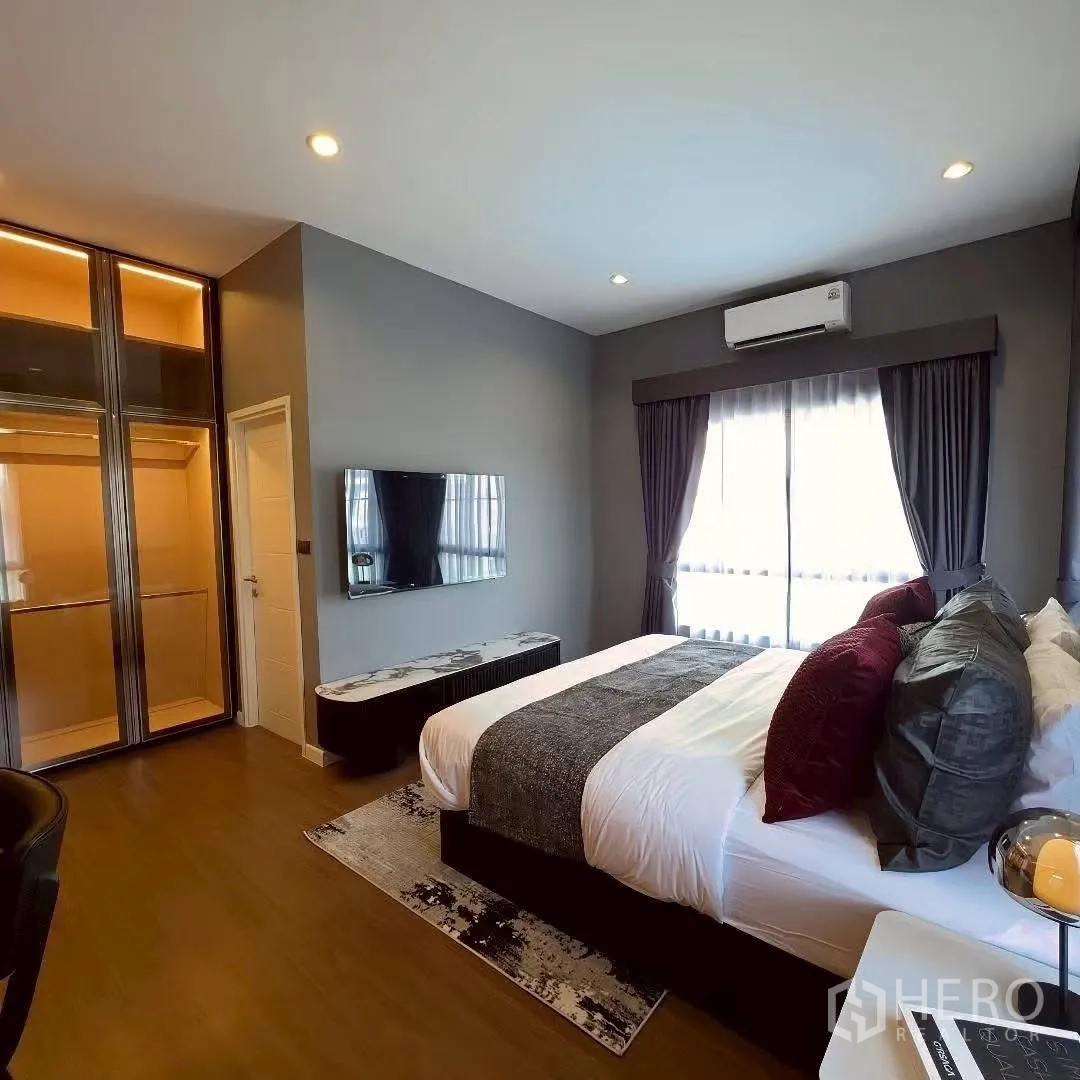Detached House for rent in Bang Phli, Samut Prakan - Bedroom with wall-mounted TV, glass wardrobes, and dark drapes.