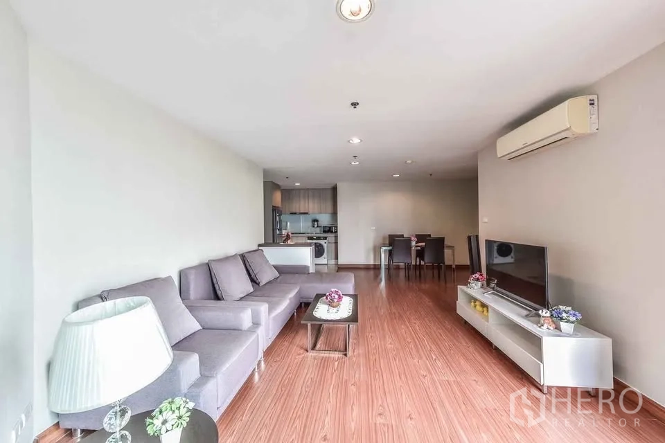 คอนโด for rent in Huai Khwang, Bangkok - ห้องนั่งเล่นแบบเปิดโล่งพร้อมโซฟา L‑shape ชั้นวางทีวี และพื้นไม้
