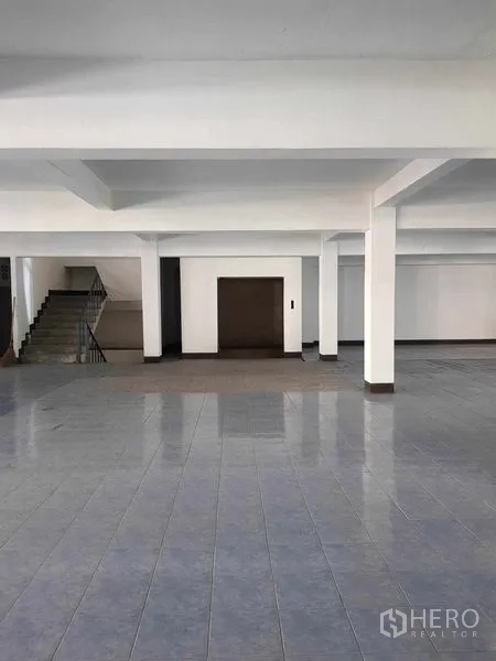 Warehouse for rent in Nong Khaem, Bangkok - Warehouse interior showing a freight elevator door and staircase.
