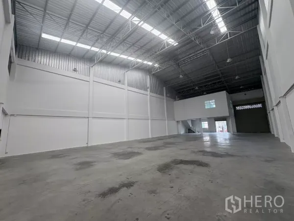 Factory for rent in Phra Samut Chedi, Samut Prakan - Wide warehouse view toward the mezzanine office and roller shutter loading bay.