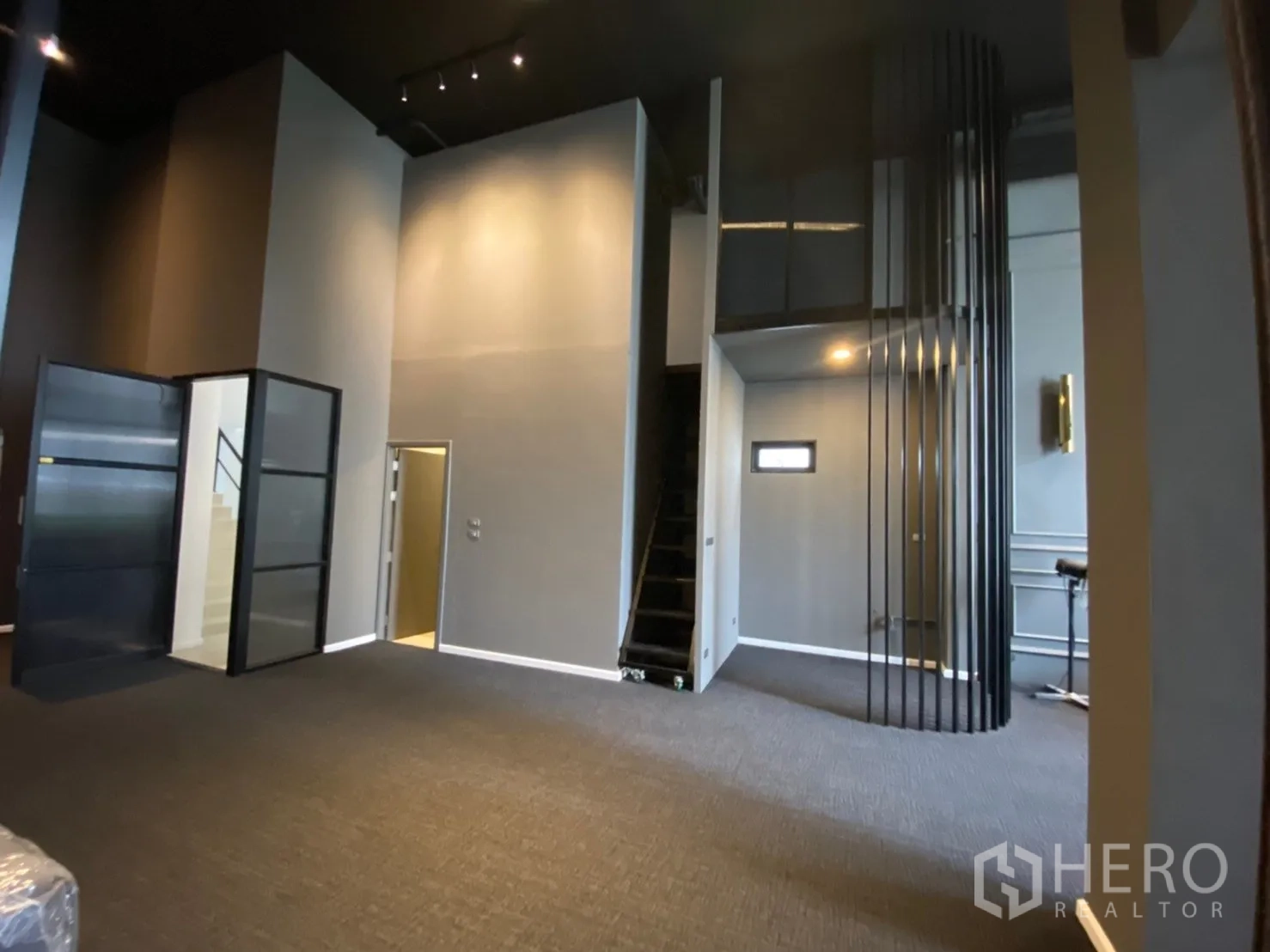 带办公室的家 出租或出售在Watthana, Bangkok - 挑高工作区，带楼梯、玻璃门与工业风黑色天花。