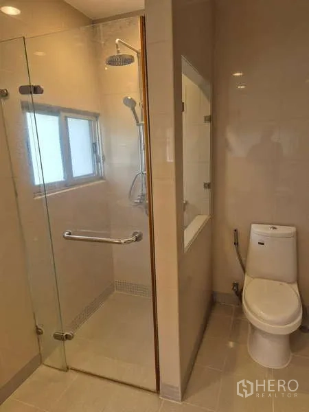Detached House for rent in Bang Kruai, Nonthaburi - Modern bathroom with glass-enclosed rain shower and toilet.