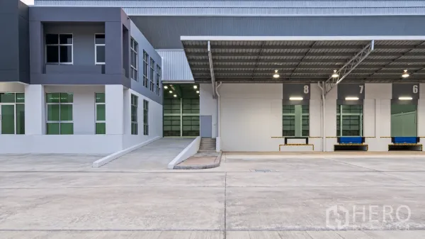 Warehouse for rent in Si Racha, Chon Buri - Warehouse exterior with covered loading bays, ramp access, and an attached office block.