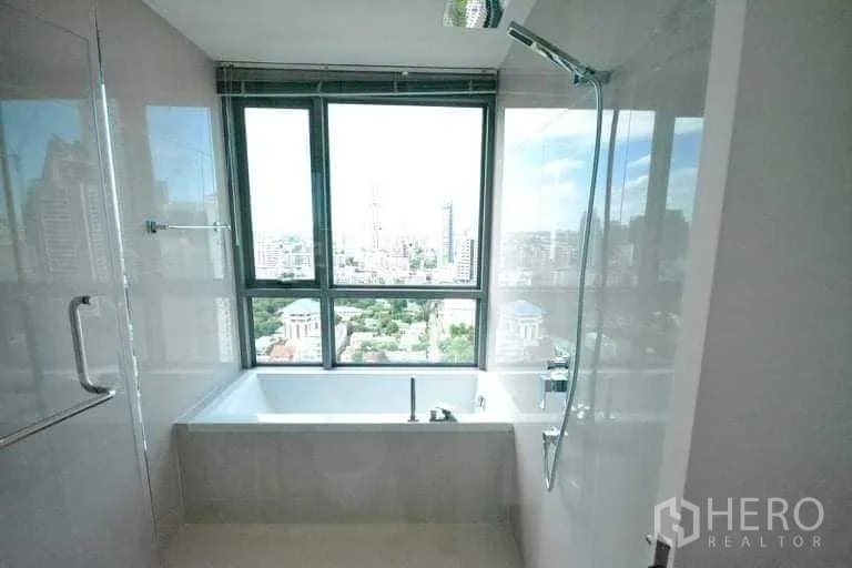 Condominium for rent or sale in Phra Khanong, Bangkok - Bathtub and shower next to a picture window showcasing the Bangkok city view.