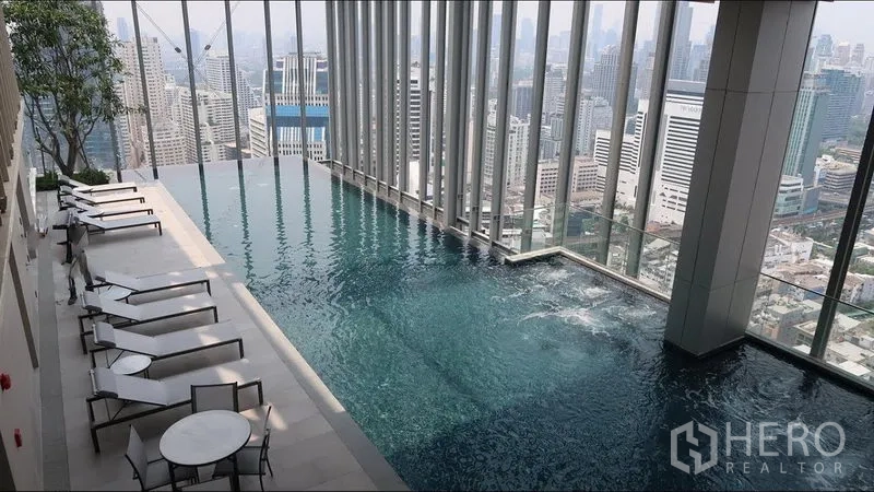Condominium for rent in Watthana, Bangkok - Rooftop infinity pool with sun loungers and panoramic Bangkok skyline views.
