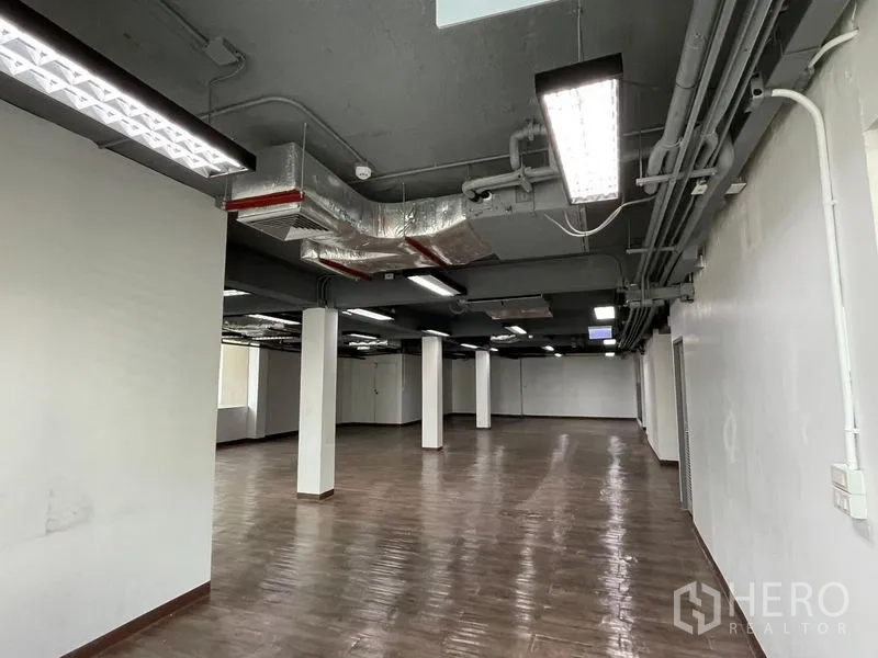 สำนักงาน ให้เช่าในRatchathewi, Bangkok - ทางเดินพื้นที่สำนักงานแบบเปิดยาว มีท่อดักท์ เสา และไฟฟลูออเรสเซนต์