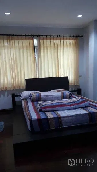 บ้าน ขายในBang Na, Bangkok - ห้องนอนพร้อมเตียงแพลตฟอร์ม ผ้าม่านโทนอ่อน และไฟดาวน์ไลท์