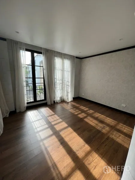 带办公室的家 出租或出售在Watthana, Bangkok - 阳光卧室，木地板与通阳台的玻璃门。