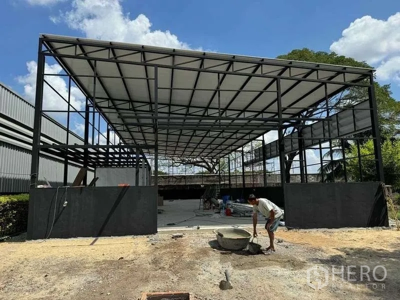 Warehouse for rent in Mueang Pathum Thani, Pathum Thani - Facade of new-build warehouse highlighting tall canopy and perimeter half-walls.
